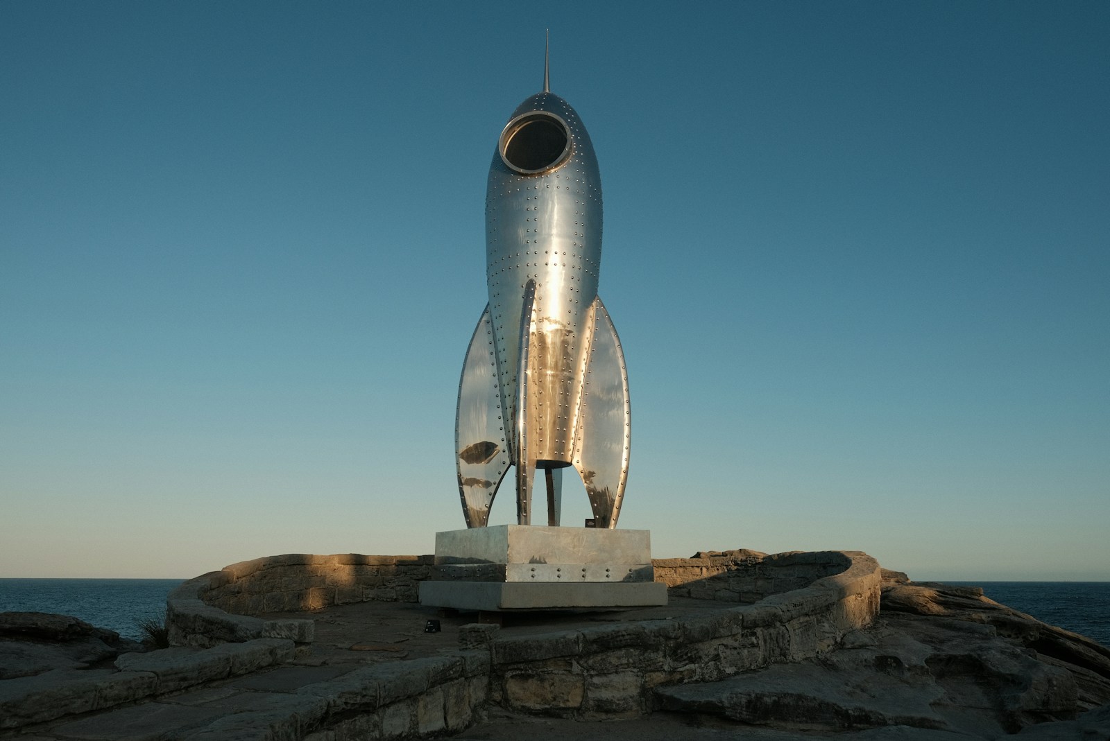 A statue of a rocket sitting on top of a rock